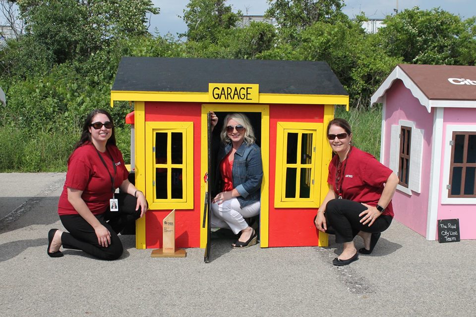Leigh-Ann Allaire Perrault and CUMIS employees post with one of the winning playhouses.