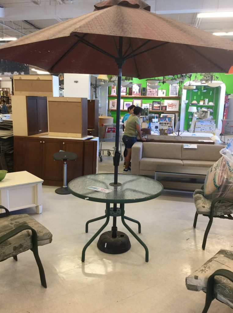 A set of outdoor chairs and a table with an umbrella available for sale in our Mississauga ReStore.