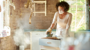 DIY furniture photo shows a female sanding a cabinet.