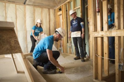 Habitat for Humanity construction crew laying down the flooring of an affordable home