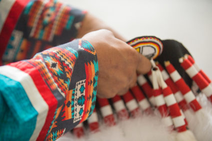 Flying Dust First Nation, close up of an indigenous person's hands with a traditional garment